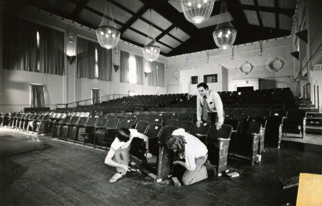Black and white photo of the Atheneum Turners Building theatre with workers installing theatre seats.
